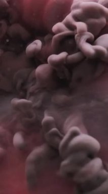 Dikey video. Haze girdabı. Sis sıçraması. Soyut sanat arka planında yüzen su akışkan duman dokusunda çözünmüş pembe metalik mavi boya..