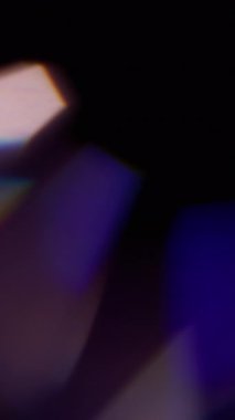 Dikey video. Bokeh ray. Bulanık, parlak bir parıltı. Soyut koyu siyah arkaplanda yüzen mavi kırmızı renkli yuvarlak mercek optik parlaklığı.
