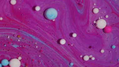 Mürekkep damlası. Suyu boya. Odaklanmamış pembe renkli damlacıklar soyut sanat arka planında yüzen beyaz mor akrilik yağ damlatırlar..