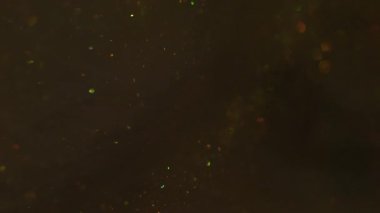 Parıltı akışı. Sanat bulanıklığı parıltısı. Parıldayan karışım parçacıkları bokeh kıvılcımlarında harmanlıyor. Renkli altın metalik boya akışı soyut arkaplan.
