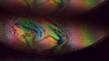 Gökkuşağı emülsiyonu çözüldü. Yüzen mürekkep. Siyah arka planda çift renkli sıvı kemer yağı girdabı. Çember lens soyut gradyan parıltısı.