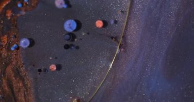 Mürekkep döküldü. Parıldayan sıvı. Odaklanmamış turuncu mor renkli yağ yuvarlak akışı soyut arkaplanda köpük dokusu çemberi oluşturur.