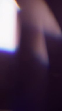 Dikey video. Sızdıran ışın. Bulanık bir parlama. Odaklanamayan mavi yeşil renkli gökkuşağı tayfı soyut sanat arka planında parıldıyor..