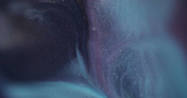 Bulanık renkli su. Boya akışı. Odaksız mavi mor kimyasal sıvı soyut sanat yaratıcılığı arka planında yüzen ışıltılı pigmentler..