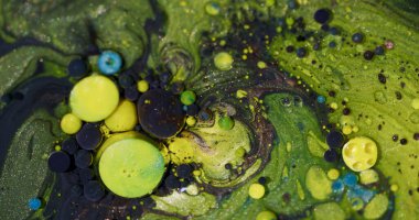 Renkli boya. Köpük jeli. Soyut akrilik sanat arka planında yüzen sıvı sıvı yağ damlacığının etrafında çözünmüş sarı mavi parıltı.