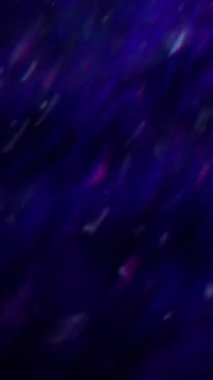 Dikey video. Parlak bir işaret fişeği. Odaklanamayan gökkuşağı yansıması. Mavi renk parıldayan lensler bulanık koyu siyah soyut arka planda hareket ediyor..