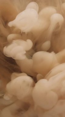 Dikey video. Sis rengi. Sıvı mürekkep. Odaklanamayan sarı buhar dokusu ruhani dalga su akışı soyut yaratıcı sanat kara fon üzerinde yüzüyor..