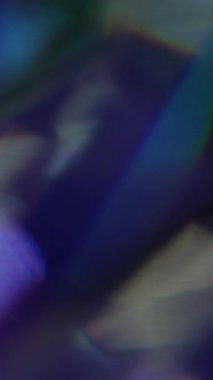 Dikey video. Işık huzmesi. Bulanık gökkuşağı lensi. Odaklanamayan sarı mor çok renkli desen, soyut sanatın koyu siyah arka planında parıldıyor..