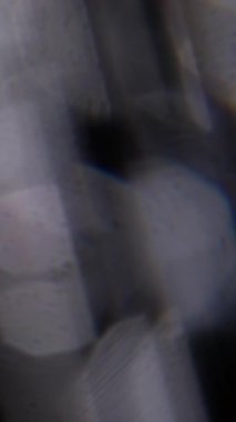 Dikey video. Bulanık görsel göz kamaştırıcı. Sanat parıltısı. Odaklanmamış lens parıltısı soyut koyu siyah bokeh açık arkaplan üzerinde yüzen mavi sarı spektrum deseni.