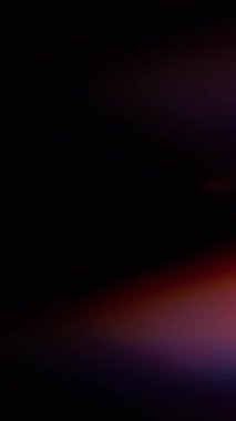 Dikey video. Parılda. Bulanık lazer. Soyut sanatın koyu siyah zeminine odaklanmış mavi yeşil çok renkli gökkuşağı spektrum ışığı.