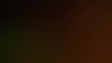 Odaklanamayan parlaklık. Yanık bulanıklığı. Siyah kahverengi soyut arkaplanda parlak bir ışık parlaması. Eski film yansıması sanat efekti.