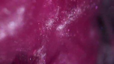 Köpüklü sıvı. Mürekkep bulanıklığı dalgası. Mor pembe kum metalik duman suyu harmanlıyor. Parlak akış sıçrama yayılan renk soyut siyah arkaplan.