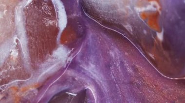 Dikey video. Eriyen sıvı. Buz dokusu. Bulanık mor turuncu mavi renkli parlak mürekkep soyut donmuş akrilik arka planda yüzen beyaz su akışı.