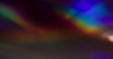 Optik sızıntı bulanık. Gökkuşağı parıltısı. Holografik mavi kırmızı kristal yansıma parlaklığı siyah arka planda. Renkli soyut ışıltı.