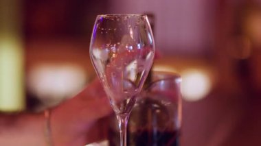 Kokteyl yapımı. Alkollü içki servisi. Barmen eli gergin kırmızı sıvı metal elek fırlatıyor. Bar tezgahında profesyonel bir içecek hazırlama..