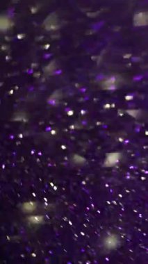 Dikey video. Parlak yansıma. Bulanık ışıklı ışın. Soyut ışık arkaplanında yanıp sönen çok renkli mor parıltılı parıltı..