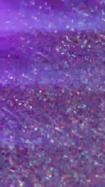 Dikey video. Çok renkli parçacıklar. Bulanık parıltı parıltısı. Lens, Bokeh Işığı 'nın soyut arka planında yüzen mor mavi altın sıvıyı parlatır.