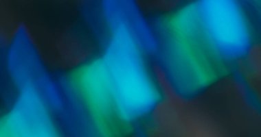 Prizma Bokeh lensleri. Kaçak aydınlatma. Siyah dokuda neon rengi kaleydoskop etkisi. Mavi yeşil soyut odaklanmış sanat arkaplanı.