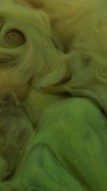 Dikey video. Boya damlası. Atmosferik duman. Odaklanamayan mavi yeşil renk bulut su sıvısı kimyasal sıçrama soyut arka planda yayılıyor.