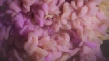 Mürekkep dokusu karışımı. Boya sıçraması. Odaklanamayan sarı mor parlak sıvı soyut sanat üzerine yayılıyor koyu siyah yaratıcı arkaplan.