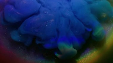 Işıldayan sıvı. Mürekkep girdabı. Pembe arka planda mavi parlak toz karışımı. Bulanık parlak gökkuşağı ışık kemeri soyut renk suyu.