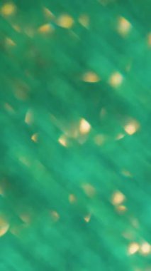 Dikey video. Parıltı parlıyor. Odaklanmamış parıltı dokusu. Pürüzsüz bulanık bokeh pembe sarı çok renkli arkaplanda süzülen ışık parçacıkları mercek parlaklığı.