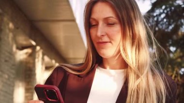 Dostça bir arama. Hoş sohbetti. Kendinden emin gülümseyen, memnun iş kadını telefon elektronik cihazıyla kadın sohbeti dışında konuşuyor..