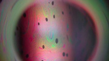 Uzay bulanıklık küresi. Yağ pigmenti. Çok renkli ışık arkaplanındaki daire lensler. Soyut yüzen benzin mürekkebi kırmızı yeşil siyah sıvıyı harmanlıyor.