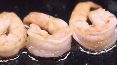 Karides pişiriyorum. Gurme yemekleri hazırlıyorum. Kara yağ tenceresinde soyulmuş deniz ürünleri ızgarası. Aromatik çıtır çıtır kabuklu meze. Yemek için malzeme..