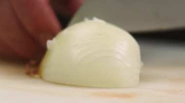 Yiyecek doğrama işlemi. Malzeme doğruyorum. Mutfak tahtasındaki bıçaklı beyaz soğanı ustalıkla hazırlıyorum. Şef vejetaryen tarifi yapıyor..