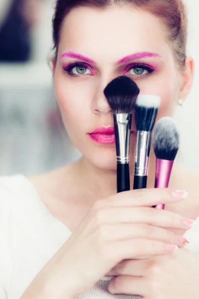 De make-up artiest houdt poeder borstels — Stockfoto