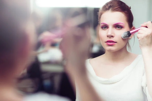 La muchacha con brillante rosado el maquillaje aplica el rubor —  Fotos de Stock