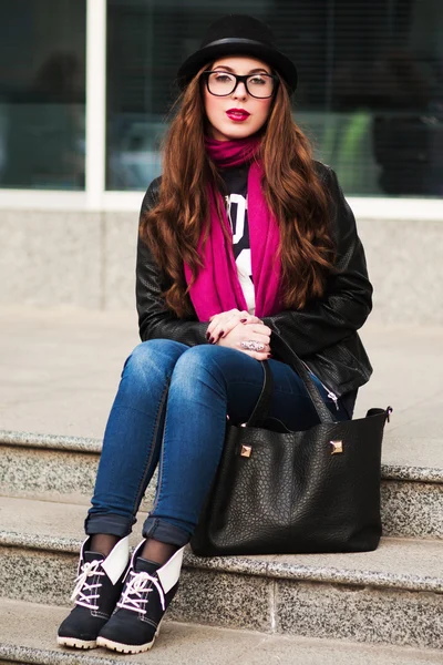 Стильная городская девушка в солнцезащитных очках сидит на ступеньках — стоковое фото