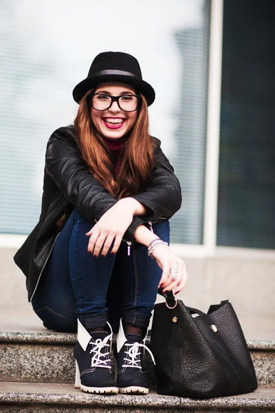 Stylowe roześmiany szczęśliwy miasta dziewczyna w okulary siedzi na ste — Zdjęcie stockowe