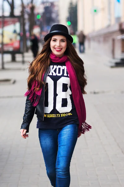 Модная смеющаяся девушка ходит по улицам города — стоковое фото