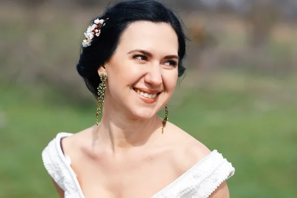 La sposa ridente felice con fiori in capelli — Foto Stock