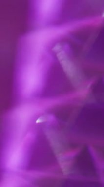 Dikey video. Odaklanamayan ışık üçgenleri. Enerji geometrisi. Sarı, kırmızı, mor, parlak, parlak, mercek, soyut, bulanık arkaplanda parlıyor..