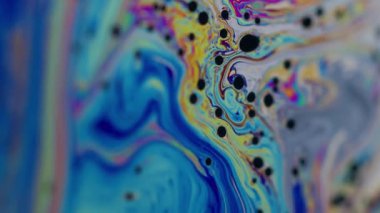 Dikey video. Gökkuşağı erimiş yağ. Boya karışımı. Çok renkli sıvı mavi dalgalı pigment arkaplanı. Soyut benzin deseni sıvısı.