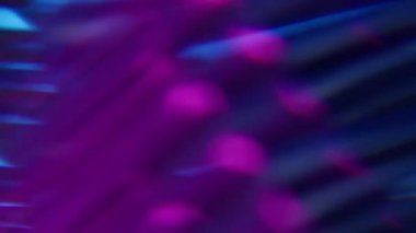 Görüntü pırıltısı. Parlak doku. Soyut koyu arkaplan üzerinde hareket eden sönük mor mavi neon renkli optik parıltı mercek parlaklığı.