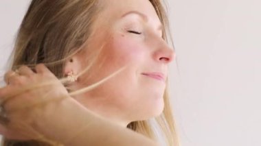 Kadınsı uyum. Neşeli rahatlama. Mutlu, huzurlu kadın yüzü rüzgar dalgalı saçlarına dokunuyor..