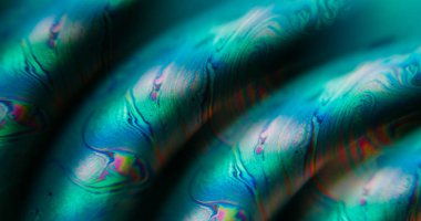 Odaklanmamış damlacık dokusu. Benzin sızıntısı. Soyut neon sanat arka planında yüzen yeşil turuncu mavi renkli akrilik boya balonu.