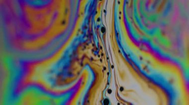 Dikey video. Renkli bulanık sıvı. Yanardöner sabun. Gökkuşağı kabarcığı fantezi parlak sanat mürekkebi su yüzeyinde dönüyor. Neon boya karışımı soyut arkaplan.