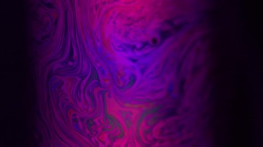 Kimyasal bulanıklık. Boya karışımı. Çok renkli, sıvı, canlı, pigment siyah arkaplan. Soyut neon mor kırmızı sıvı.