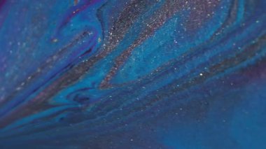 Akış akışı. Boya sıvısı. Odaklanmamış mavi mor renkli parlak neon su parçacıklarını soyut bokeh arkaplan üzerine sıçratır.