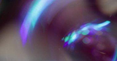 Prizma Bokeh lensleri. Kaçak aydınlatma. Neon renkli küre siyaha yansıyan kaleydoskop dönüşü. Mor mavi soyut bulanık arkaplan.