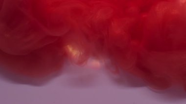 Boyayla boyanmış. Mürekkep buharı. Turuncu kırmızı, beyaz arka planda çözünen ışıldayan akıntıya odaklanmış. Soyut renk, duman damlası sızıntısı dokusu.