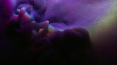 Mistik boya. Parıltı spreyi. Mor menekşe duman tozu mürekkebi siyah soyut arkaplanda dökülmüş. Odaklanmış su, parlak gökkuşağı lensi, parlak renk sıçraması..