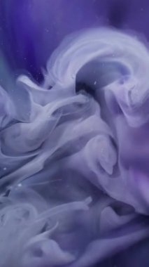 Dikey video. Duman sıçrıyor. Boya buharı. Odaklanmamış mavi mor renk sisi soyut sanat arka planına yayılan ruhani su akışı kimyasal dumanı.