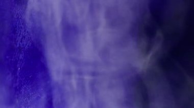 Duman buharı. Boya akışı. Odaklanmamış mavi neon rengi sis akrilik buhar suyu soyut koyu siyah arkaplanda yüzen girdap..