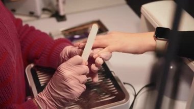 Manikür tekniği. Tırnak tedavisi. Manikürcü el Emery yönetim kurulu profesyonel iş yeri kadın eğlence süreciyle kozmetik akrilik prosedür yapıyor..